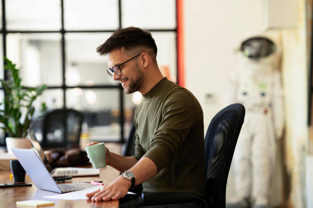 istock Young smiling man working on the project in office. 1496305853