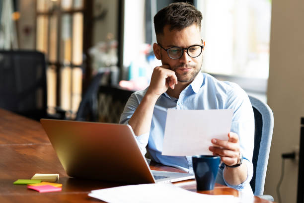 istock Young smiling man working on the project in office. 1496306385
