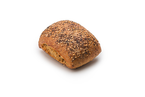 Bread with flax seeds whole and slices on white background, top view