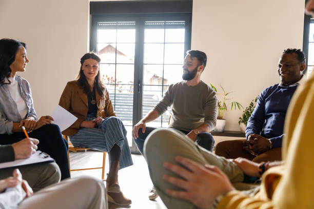 istock Group of diverse people chatting about their problems during a group therapy session 1496311958