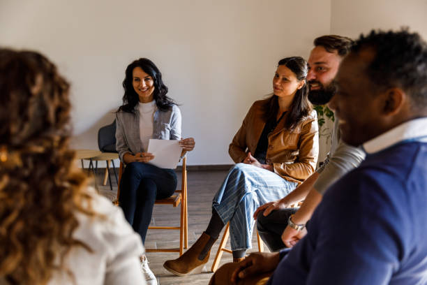 istock Woman sharing her story with a group of people during group therapy 1496312065