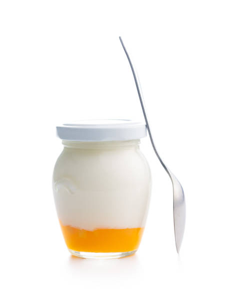 istock Fruity yogurt in jar and spoon isolated on white background. 1496312165