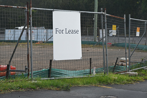 For lease sign on a temporary metal fence around a construction site