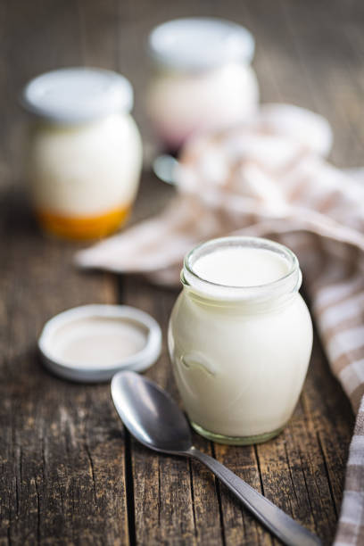 istock White yogurt in jar on wooden table. 1496312352