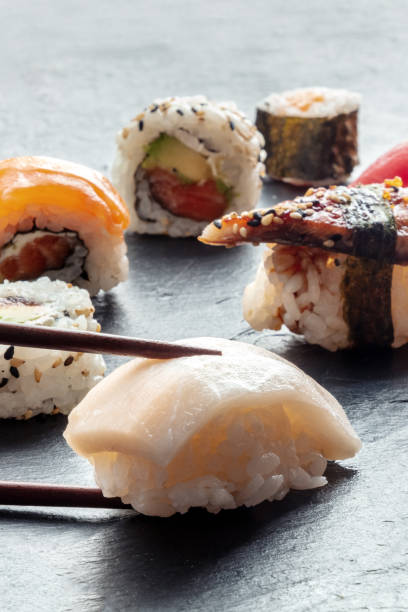 istock Sushi with chopsticks. Whitefish nigiri and rolls on a black background 1496312505