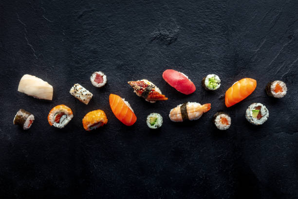 istock Sushi overhead flat lay shot. Rolls, maki, nigiri on a black slate background 1496312796