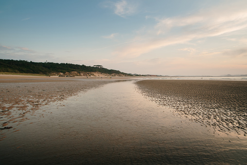 A indyllic beach at sunset and reflection on the water. Loredo beach in Cantabria, Spain