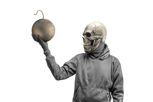 A man wearing a mask standing while holding a ball bomb on white background