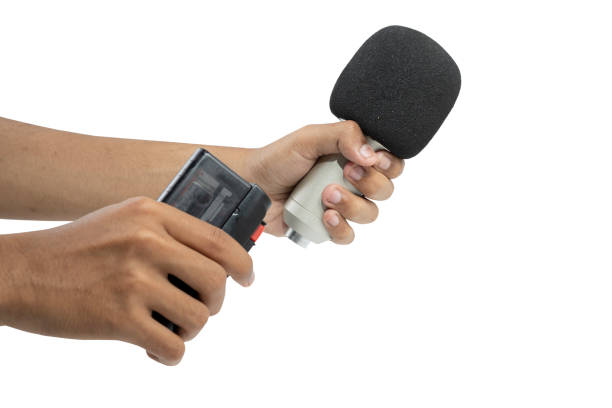 A human hand holding a microphone and recording device isolated over white background
