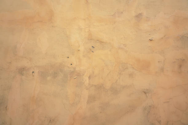istock Old shabby yellow painted cracked building facade background. 1496324913