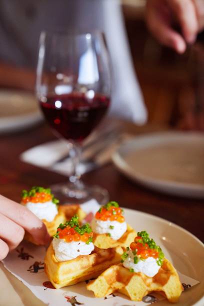 istock Delicious appetizers: fluffy waffles paired with cheese, topped with fish roe and chives 1496326208