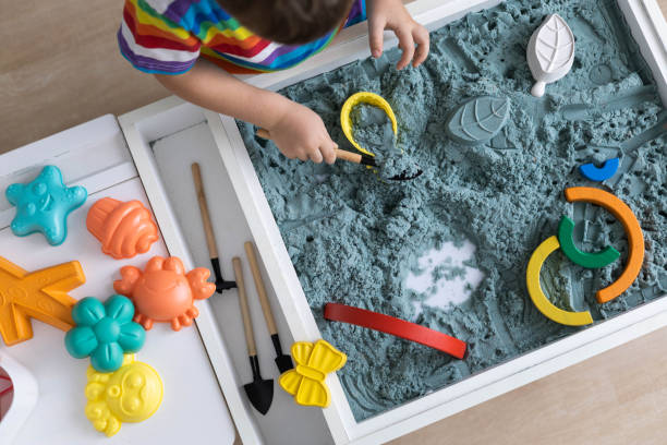 istock Overjoyed male kid playing kinetic sand early development education game fine motor skills 1496326311