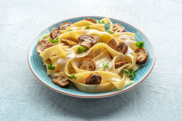 istock Mushroom pasta with creamy sauce and parsley, on a stone background 1496326873