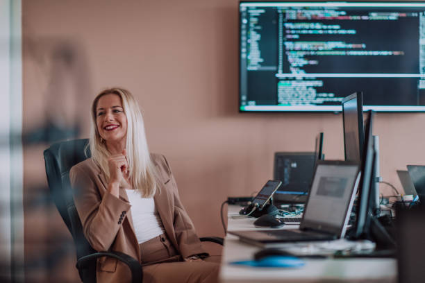 istock A businesswoman sitting in a programmer's office surrounded by computers, showing her expertise and dedication to technology. 1496327307