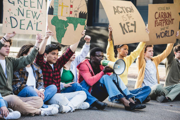 istock Group of young activists against land exploitation and climate change exercise the right to protest and make a sit in 1496330248