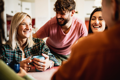 Morning breakfast at the youth hostel, different people smile and sip coffee in the cafeteria of a youth hotel, backpackers and travelers lifestyle