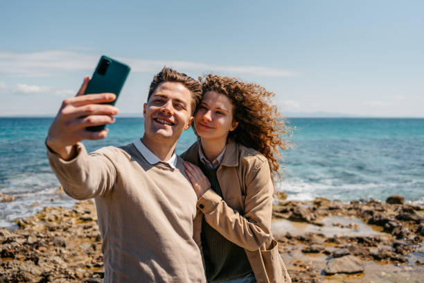 istock Young Couple Taking Selfies On The Beach In Greece 1496330974