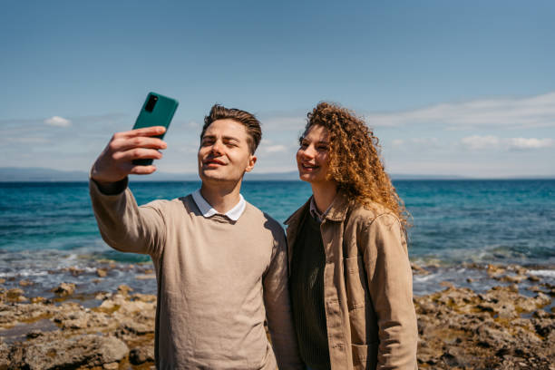 istock Young Couple Taking Selfies On The Beach In Greece 1496332088