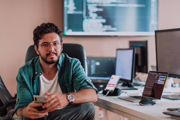 A programmer diligently testing smartphone applications while sitting in their office. A programmer diligently testing smartphone applications while sitting in their office. High quality photo checking ice hockey stock pictures, royalty-free photos & images