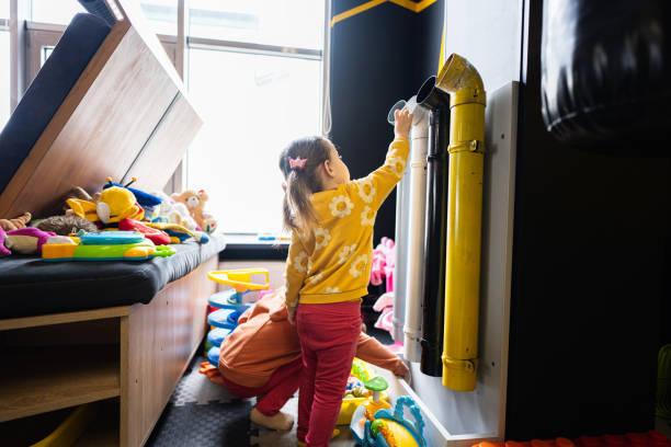 istock Two sisters throw balls inside tubes at kids play center. 1496335433