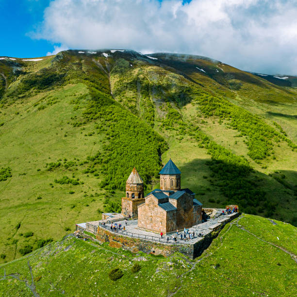 Gergeti Trinity Church against Caucasus mountains in Georgia stock photo