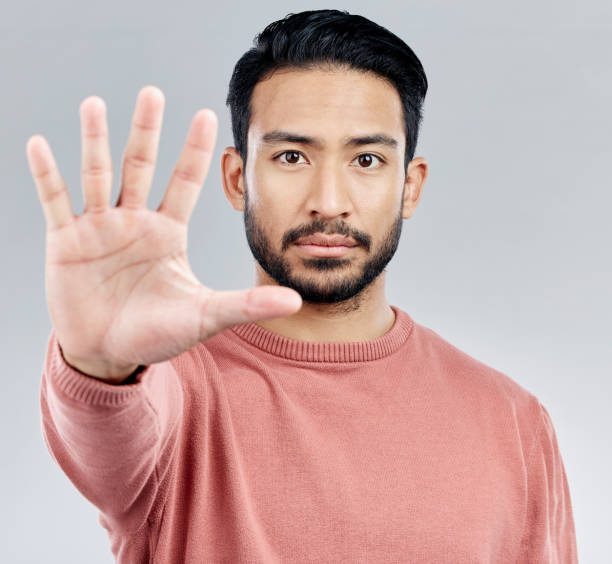 istock Portrait, five and hand for stop, Asian man and warning with serious expression against a grey studio background. Face, Japanese male and guy with gesture for halt, raising palm and showing number 1496338245