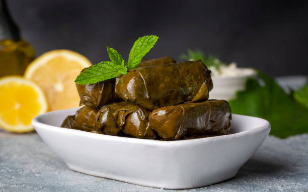 delicious dolma (sarma) stuffed grape leaves rice, white yogurt sauce. lebanese dolma sarma on plate. lebanon turkish greek middle eastern cuisine. (turkish name; yaprak sarma) - dolmades imagens e fotografias de stock