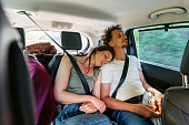 Young Couple Sleeping In The Backseat Of The Car