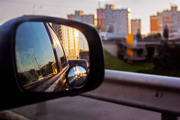 view of the sky in the right side car mirror in the evening. Traffic jam in the city