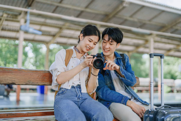 istock Young couple traveling using a camera to capture memories while waiting for the train at the station.travel concepts. 1496342303