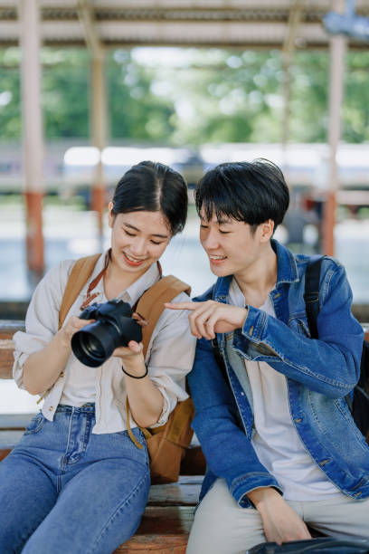istock Young couple traveling using a camera to capture memories while waiting for the train at the station.travel concepts. 1496342435