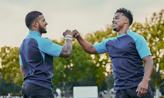 Sport, athlete men and fist bump on field for rugby teamwork, winning and success at game. Team building, happiness and support for sports friends, goals and winner to celebrate achievement together