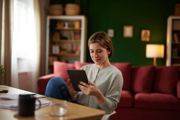 istock Women using digital tablet to check her finances at home office 1496345099