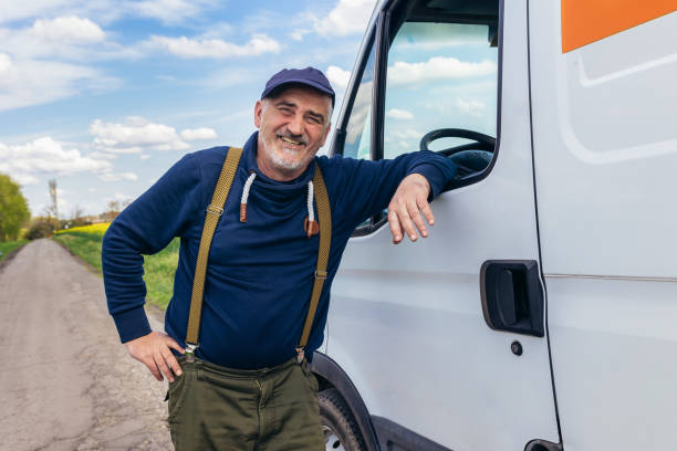 istock Happy confident male driver standing in front on his van and looking at camera. 1496346507