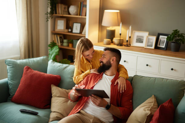 istock Handsome couple relaxing at home and looking at tablet 1496346872