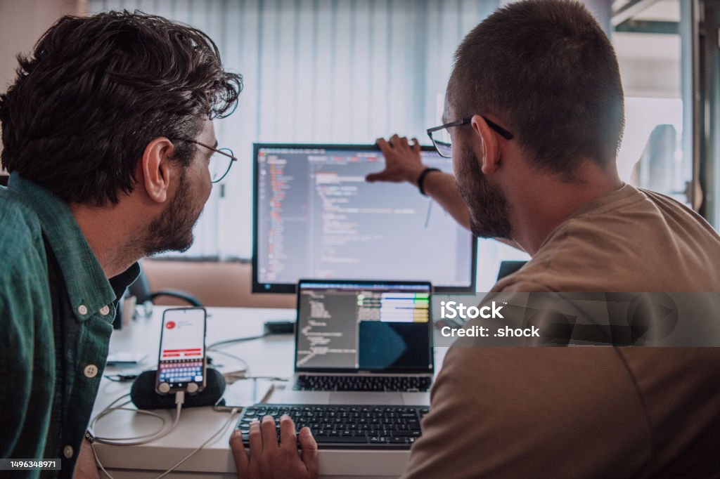 Programmers Engrossed In Deep Collaboration Diligently Working Together ...