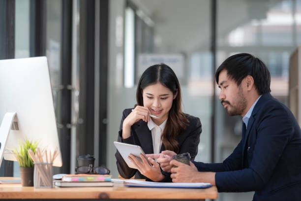 istock Business professionals. Group of young confident business people analyzing data using a computer while spending time in the office 1496349087
