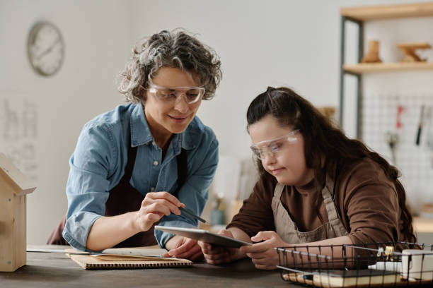istock Girl uisng tablet pc with carpenter 1496350473