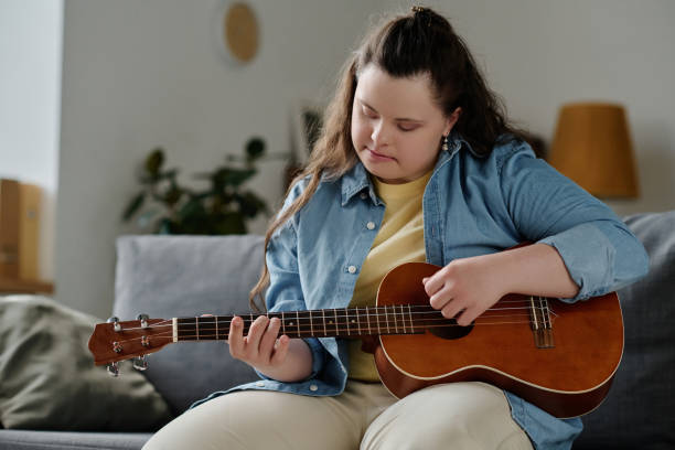 istock Girl with down syndrome playing guitar 1496352085