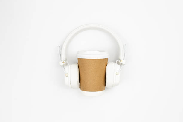 istock Disposable paper cup and headphones on a white background, top view. 1496352405