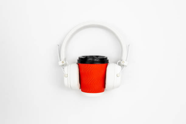istock Disposable paper cup and headphones on a white background, top view. 1496352406
