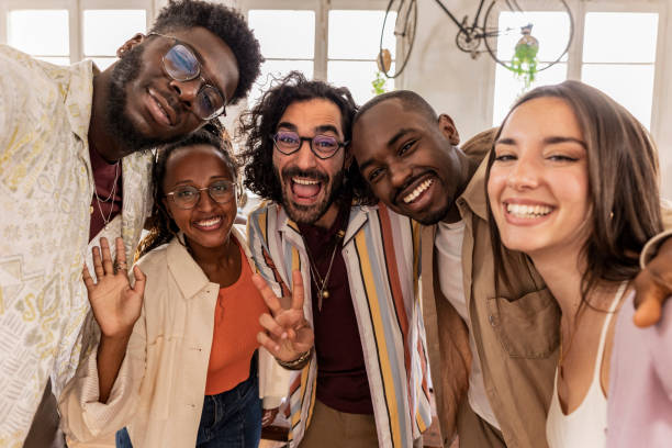 istock group of cheerful mutliracial coworkers taking selfie using smartphone in backlit loft office 1496357888