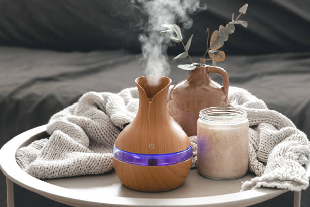 Spa composition with aroma oil diffuser lamp and candle on a blurred background. stock photo