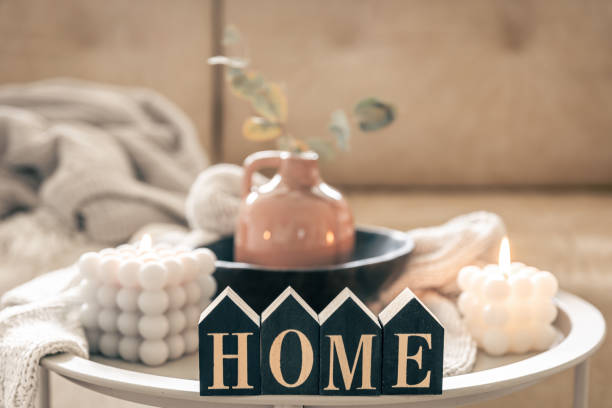 istock Cozy composition with decorative word home, candles and vase on blurred background. 1496358312