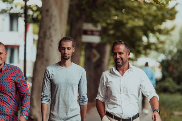 istock After a productive day at work, a group of diverse colleagues enjoy a leisurely stroll through a modern and natural urban setting 1496360307