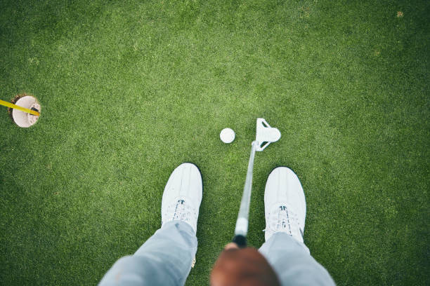 grama, buraco de golfe e homem com clube no campo para jogo, prática e treinamento para competição de golfe. golfista profissional, esportes e visão superior de sapatos masculinos bater bola para ganhar, pontuação ou tee stroke - golf green practicing sports training - fotografias e filmes do acervo