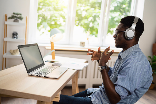 Modern and young African-American man having an online job interview from his modern home