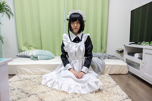 Female cosplayer sitting on heels in her room