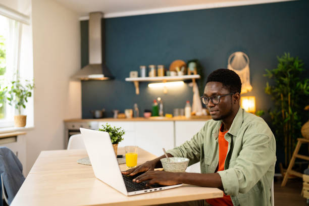 istock African-American freelancer working on laptop while having a breakfast 1496369250