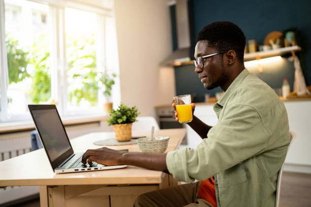 istock African-American freelancer working on laptop while having a breakfast 1496369259